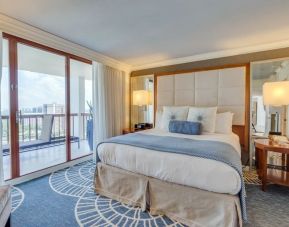 Spacious king room with balcony and natural light at Naples Grande Beach Resort.