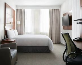 Guest room in the Club Quarters Hotel Central Loop, furnished with large double bed and desk/chair for working.