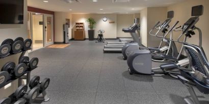 The hotel fitness center, with racks of weights and assorted exercise machinery.