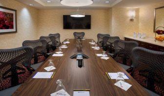 Meeting room in the Hilton Garden Inn Chicago Downtown Riverwalk, with long table, surrounding chairs and large TV.