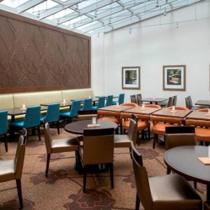 The hotel restaurant offers on-site dining, with varying table sizes and a bright and airy environment.