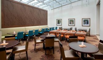 The hotel restaurant offers on-site dining, with varying table sizes and a bright and airy environment.