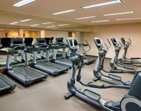 The hotel fitness center is equipped with numerous exercise machines for guests.