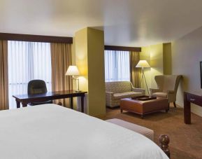 Double bed guest room in the Sheraton Houston Brookhollow Hotel, with sofa and large television.