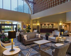 Lounge in the Sheraton Houston Brookhollow Hotel lobby, with array of comfy chairs and sofas, plus small tables.