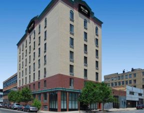 The Red Lion Inn & Suites Long Island City’s exterior, including trees on the sidewalk outside.