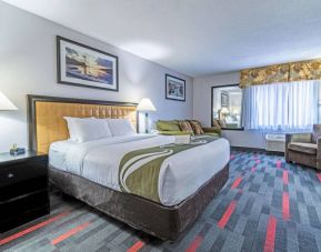 Guest room in Quality Inn Halifax Airport, with sofa, chair, and large window.