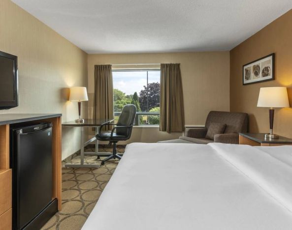 Double bed guest room in Comfort Inn Saskatoon, with window and TV.