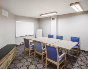 Hotel meeting room with space for half a dozen attendees around a table, and a whiteboard nearby.