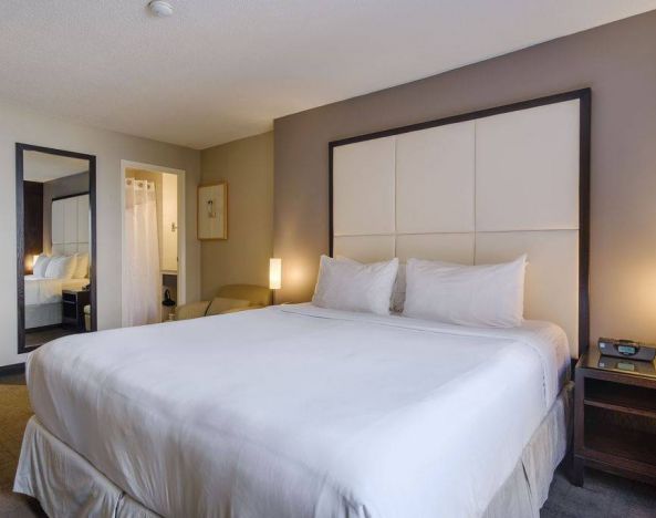Double bed guest room in Arc The Hotel Ottawa, with bedside lamps and ensuite bathroom.