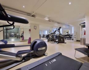 The hotel fitness center has racks of weights and multiple exercise machines.