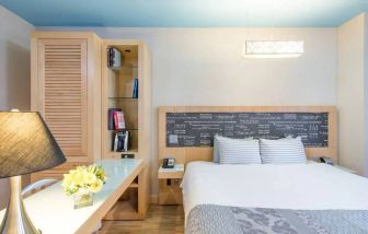 Double bedroom at TRYP By Wyndham Times Square South, including bookcase and lamp.