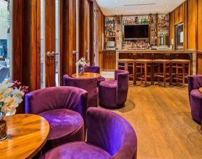 The hotel’s on-site bar, with hard floor and bright purple chairs.