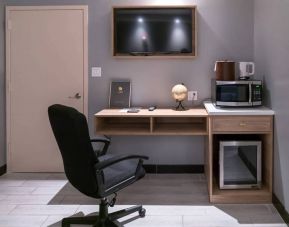 Workspace in a room at the Madison LES Hotel, including desk, chair, and microwave.