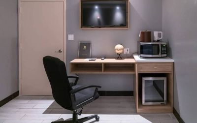 Workspace in a room at the Madison LES Hotel, including desk, chair, and microwave.