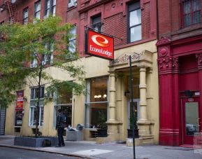 Exterior shot of the Econo Lodge Times Square, with stone awning and nearby tree.