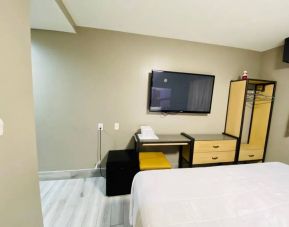 Guest room at the Rodeway Inn Cranston JFK, with space for working and large television.