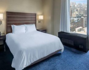 Guest room at the Hilton Fashion District, with double bed and view of the city.