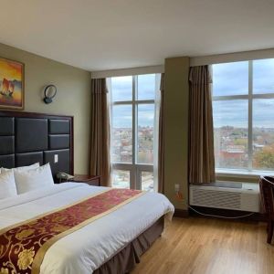 Guest room at the Queens Hotel, with double bed and large windows.
