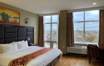 Guest room at the Queens Hotel, with double bed and large windows.