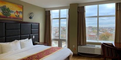 Guest room at the Queens Hotel, with double bed and large windows.