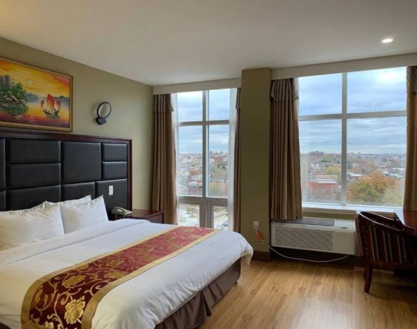 Guest room at the Queens Hotel, with double bed and large windows.