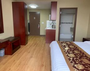 A Queens Hotel guest room, featuring a kitchenette area, and ensuite bathroom.