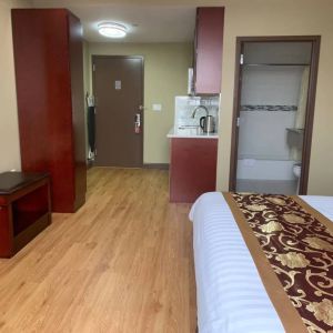 A Queens Hotel guest room, featuring a kitchenette area, and ensuite bathroom.
