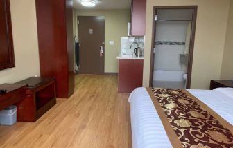 A Queens Hotel guest room, featuring a kitchenette area, and ensuite bathroom.