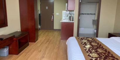 A Queens Hotel guest room, featuring a kitchenette area, and ensuite bathroom.