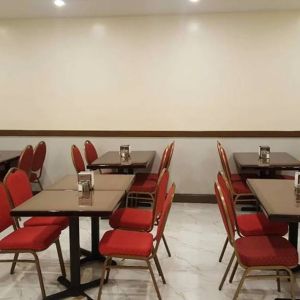 The hotel’s breakfast area, with hard floor and small tables.