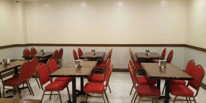 The hotel’s breakfast area, with hard floor and small tables.