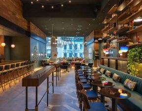 Moxy NYC Downtown’s Recreation restaurant, which has small tables and bar stool seating.