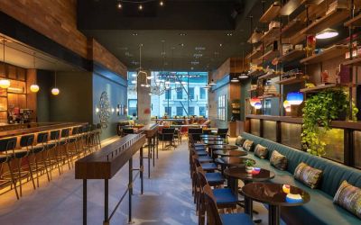 Moxy NYC Downtown’s Recreation restaurant, which has small tables and bar stool seating.