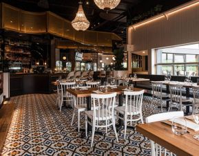 The Holiday Inn Laval Montreal’s on-site restaurant has tall bar stools and table seating.