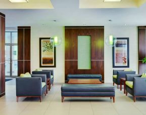 Allure Hotel & Conference Centre’s lobby has comfortable chairs, tables, and coffee tables.