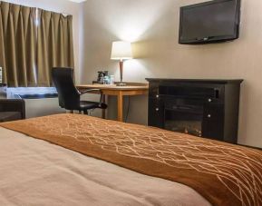 Guest room workspace in Comfort Inn Brandon, with a cozy fireplace beside the desk and chair.