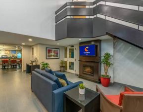 Lounge in the Comfort Inn Winnipeg Airport lobby, with comfy seating and cozy fireplace.