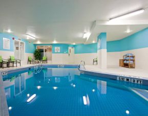 The hotel’s indoor swimming pool has nearby chairs and towels.