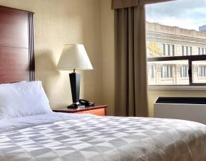 Guest room in Holiday Inn Winnipeg Downtown, with bedside lamp and window.