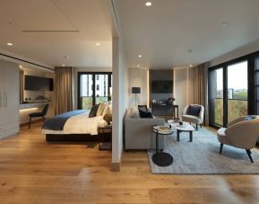 A spacious double bedroom in the Tower Suites By Blue Orchid Hotels, with lounge to the right and windows for both rooms.