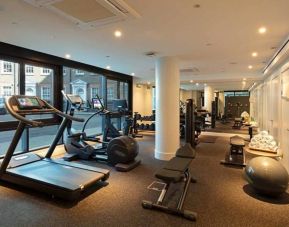 The hotel’s gym, featuring assorted exercise machines, large windows, and stacked weights.