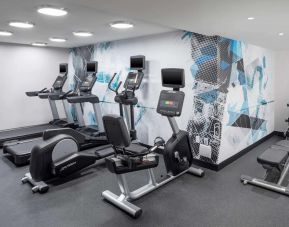 The hotel exercise center, fitted with rack of weights, bench, and multiple exercise machines.