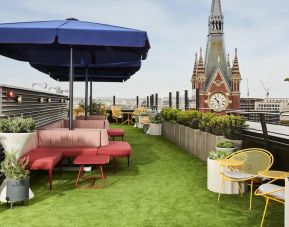 Rooftop seating, green astroturf, and the St. Pancras Clock Tower looming in the background skyline.