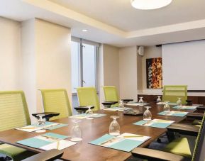 A meeting room in the Hilton Garden Inn Midtown East, with long wooden table and space for ten attendees.