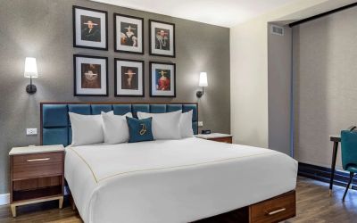 Double bed guest room in The Draper, Ascend Hotel Collection, with art on the wall above the bed, and bedside tables.