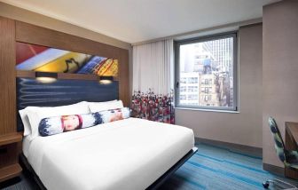 Double bed guest room in the Aloft Manhattan Downtown - Financial District, with art on the wall and large window.
