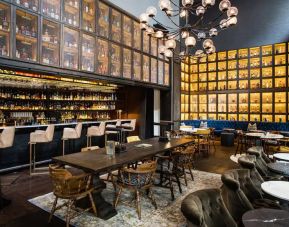 The bar and lounge of Hyatt Union Square New York, with hard floor, bar stools, and range of table sizes.