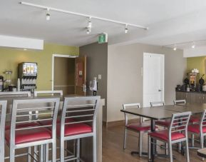 The hotel breakfast area has tall and standard chairs, and a wide range of breakfast fare.