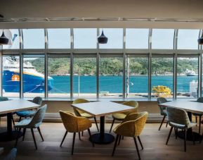 The hotel restaurant has tables and chairs overlooking the waterfront.